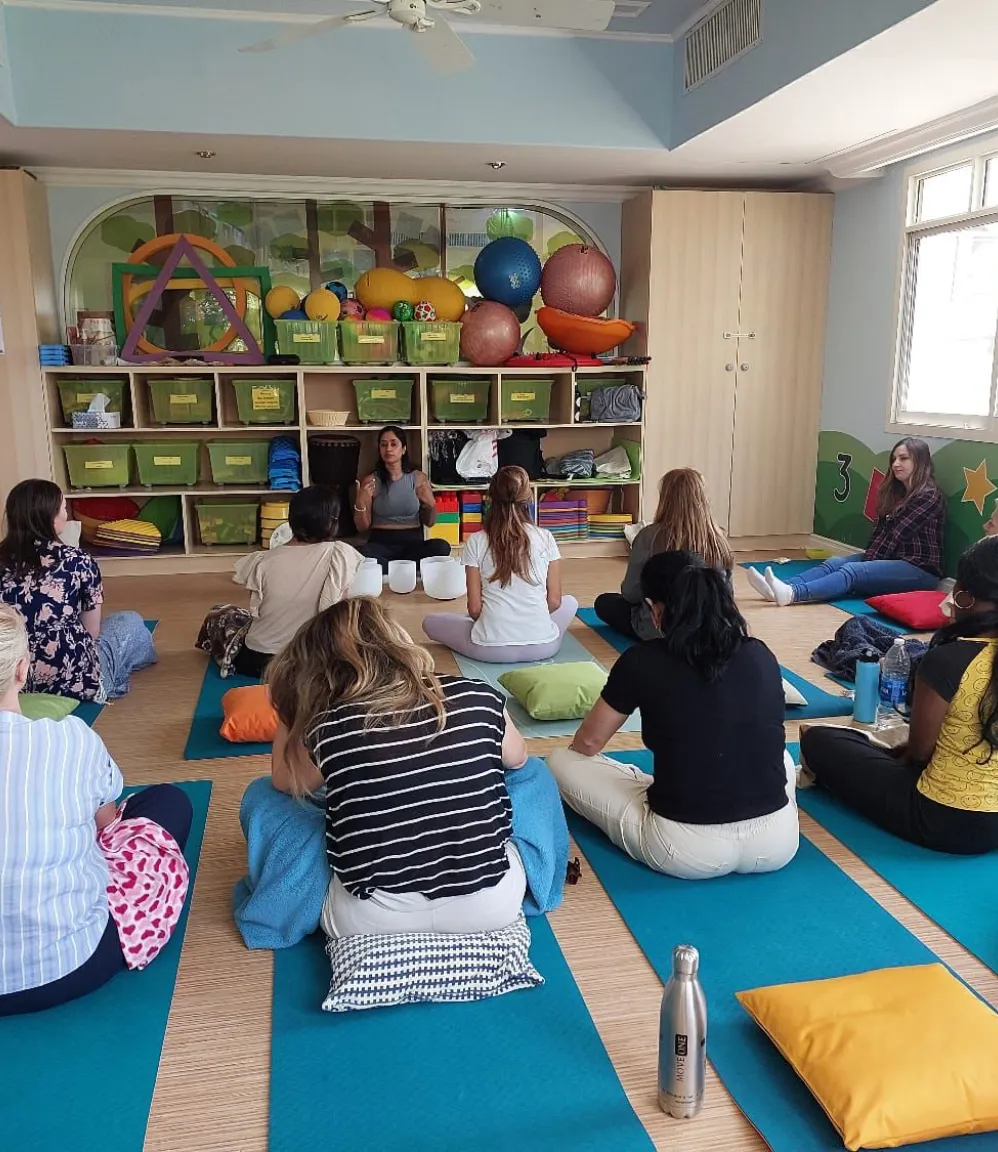 Corporate group participating in a sound healing session with singing bowls for relaxation and stress relief