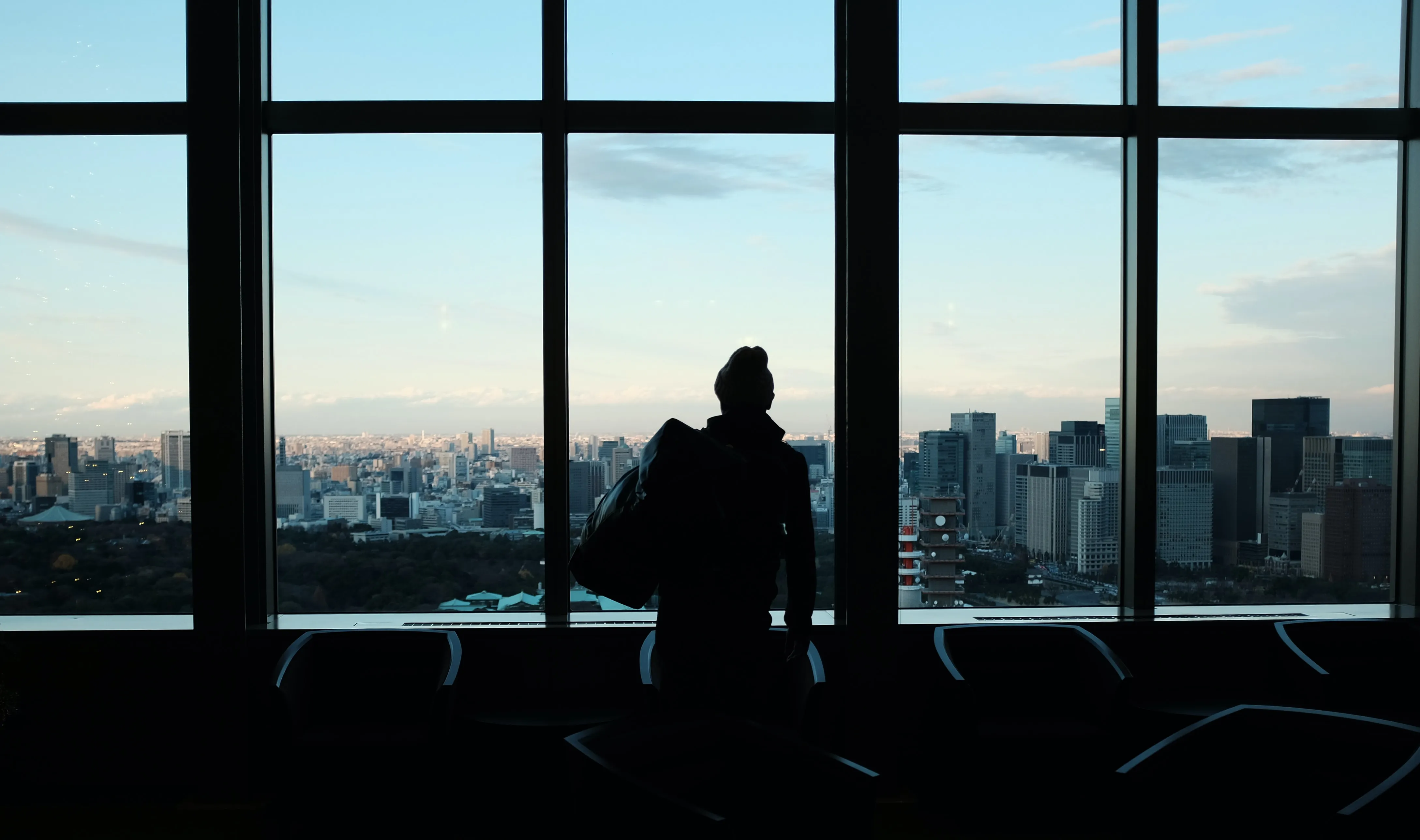man looking out a window of an office building