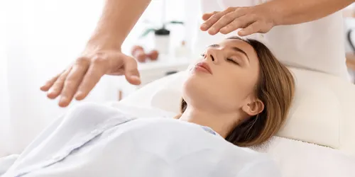 reiki practitioner holding hands over client wasatch manual therapy
