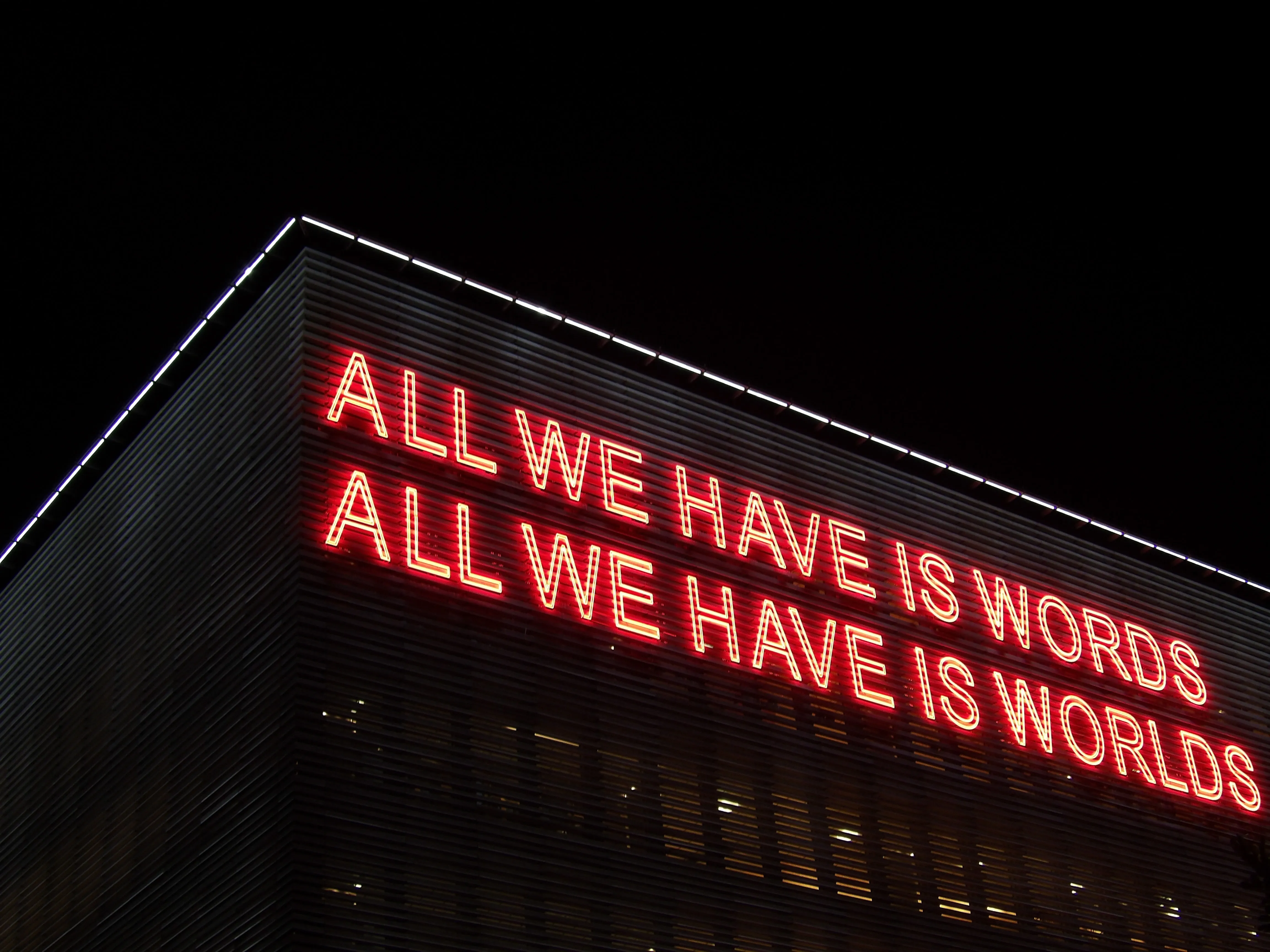 neon sign saying, all we have is words,