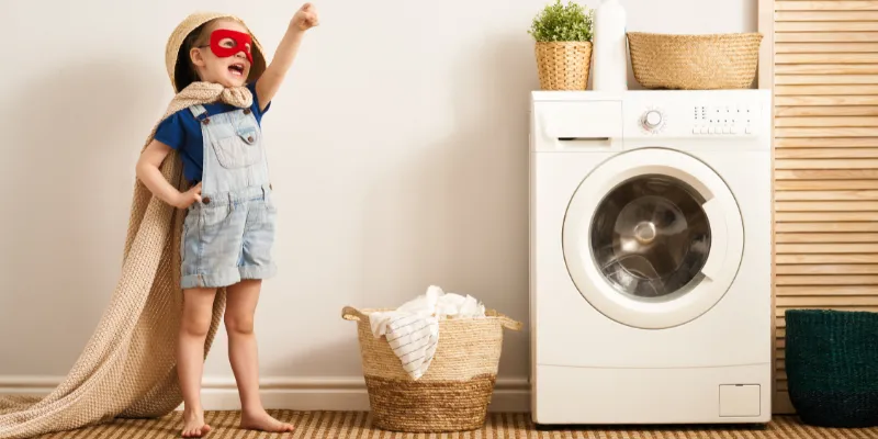 A toddler dressed in laundry acting like a superhero.