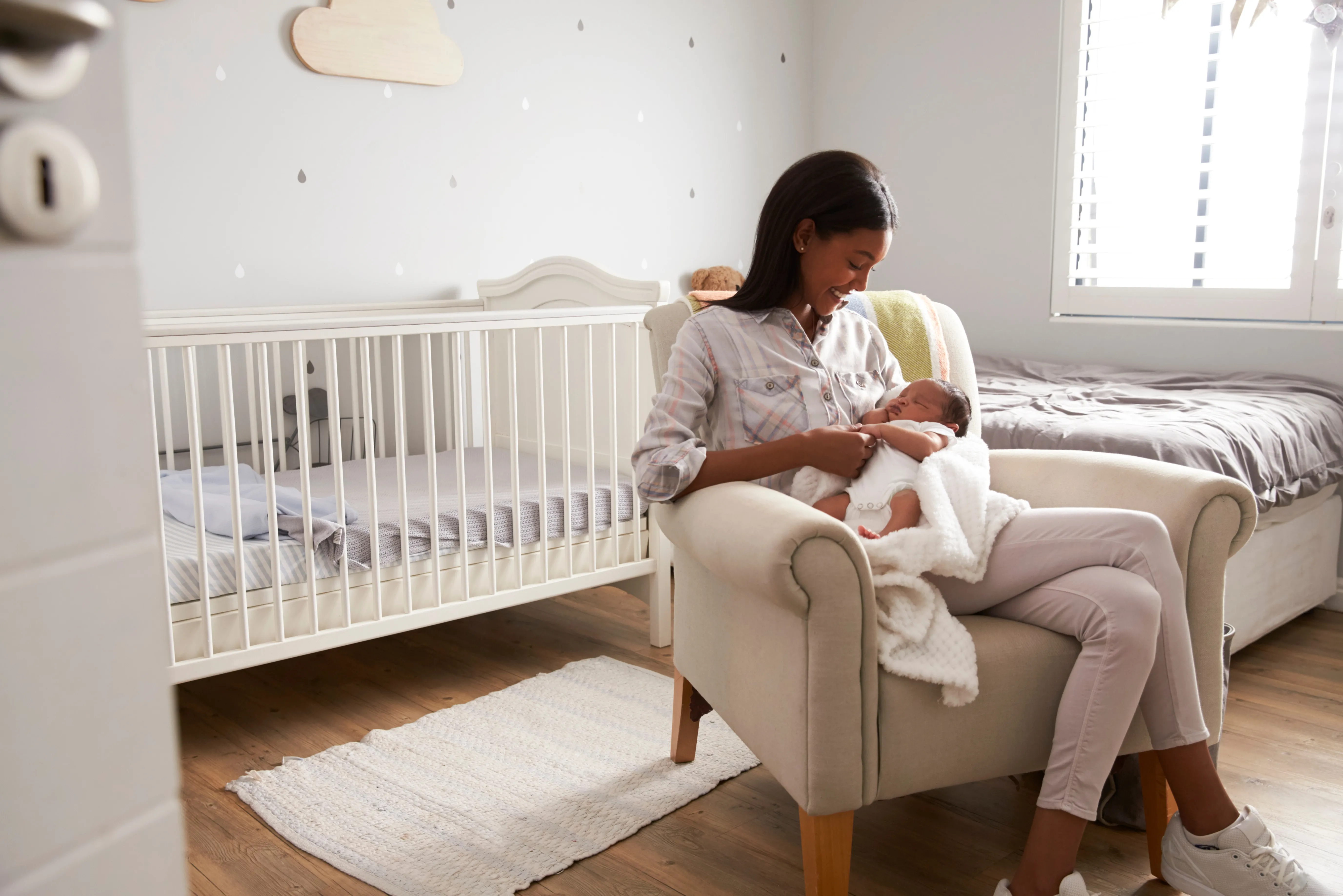 new mother holding her baby in organized nursert