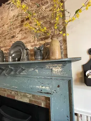 historic pewter on the mantel showing original bricks and chimney at the 1710 Tavern in Tappahannock Virginia