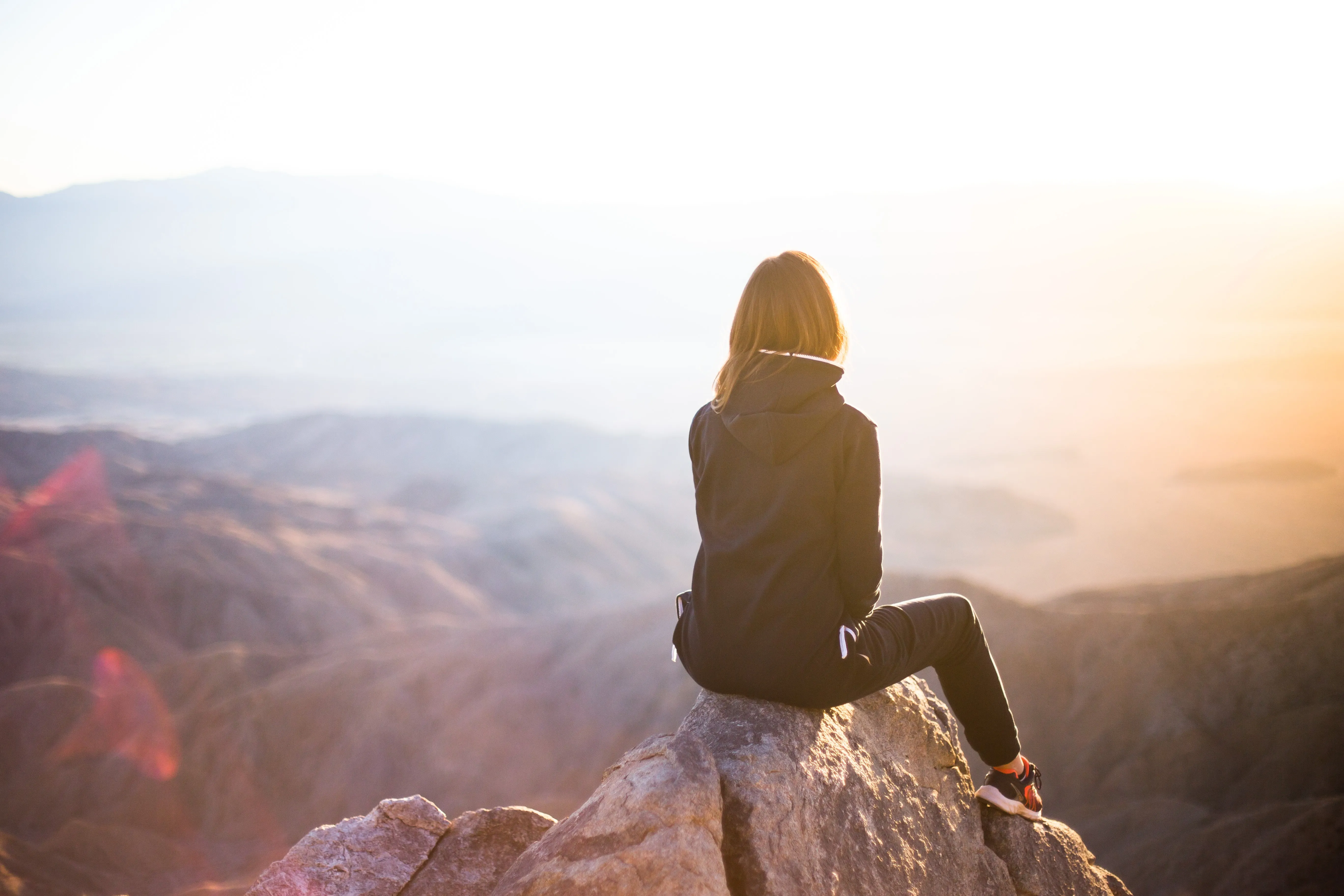 Woman sitting on rock overlooking canyon view