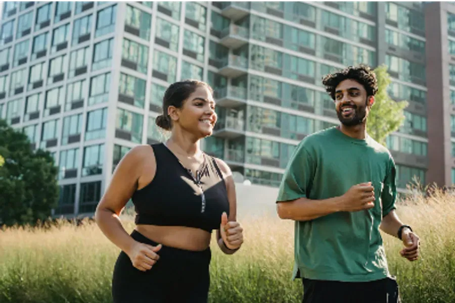 Two people running while smiling and looking happy.