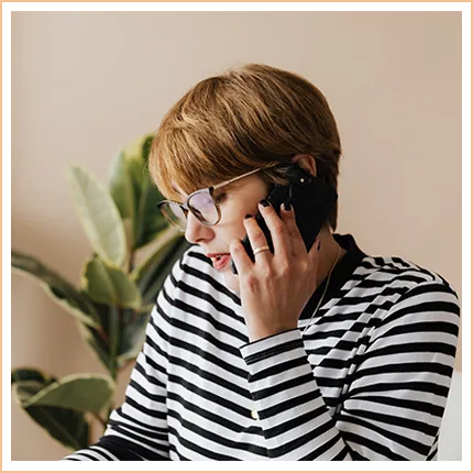 woman in striped top talking on mobile phone