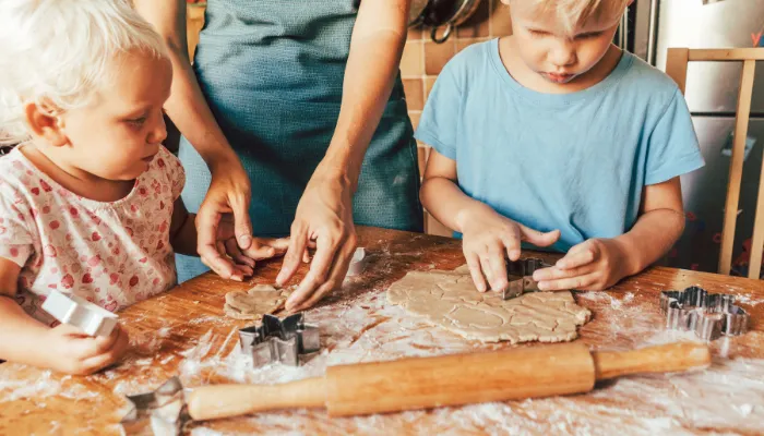 A mom making holiday cookies with her children.