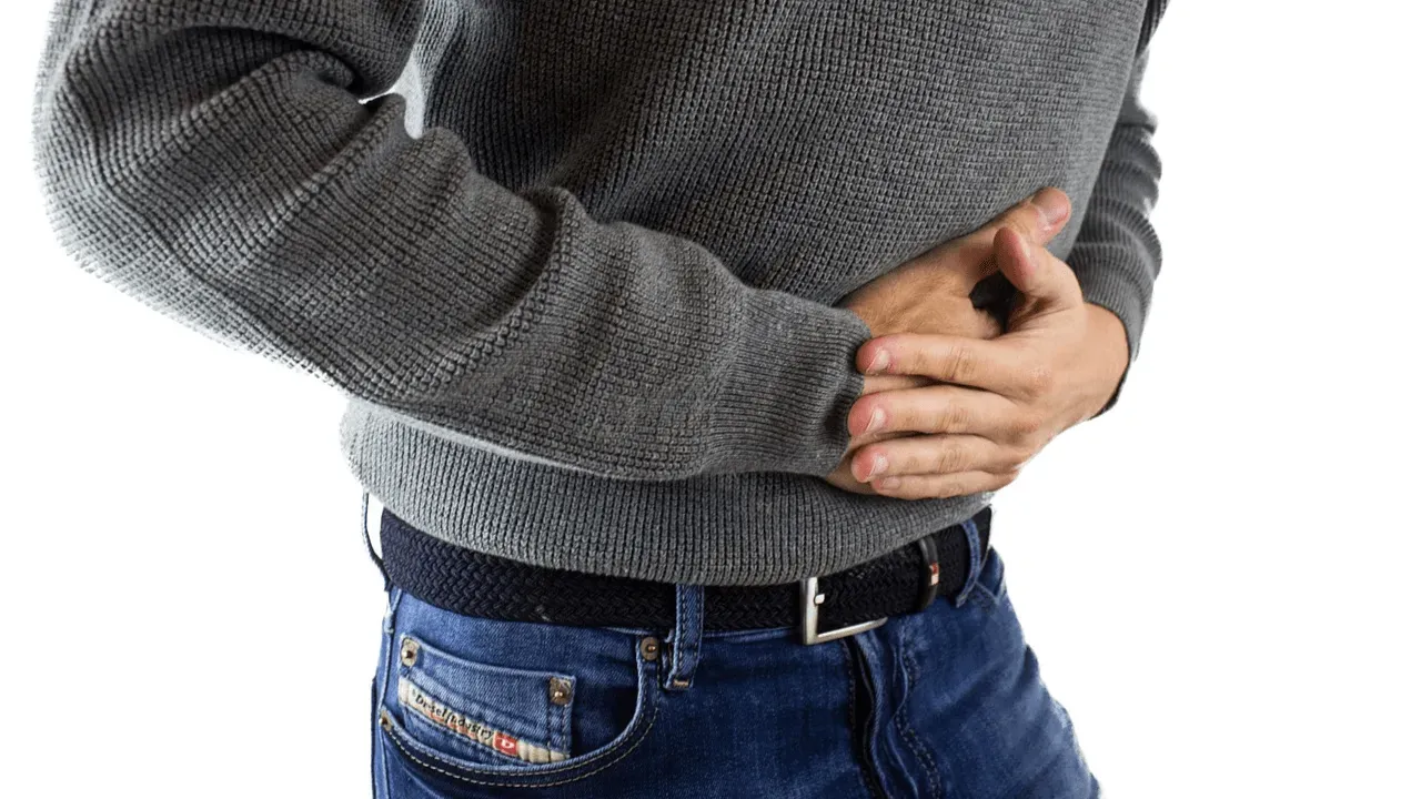 A person holding their stomach in pain, with a background depicting various weight loss supplement bottles.