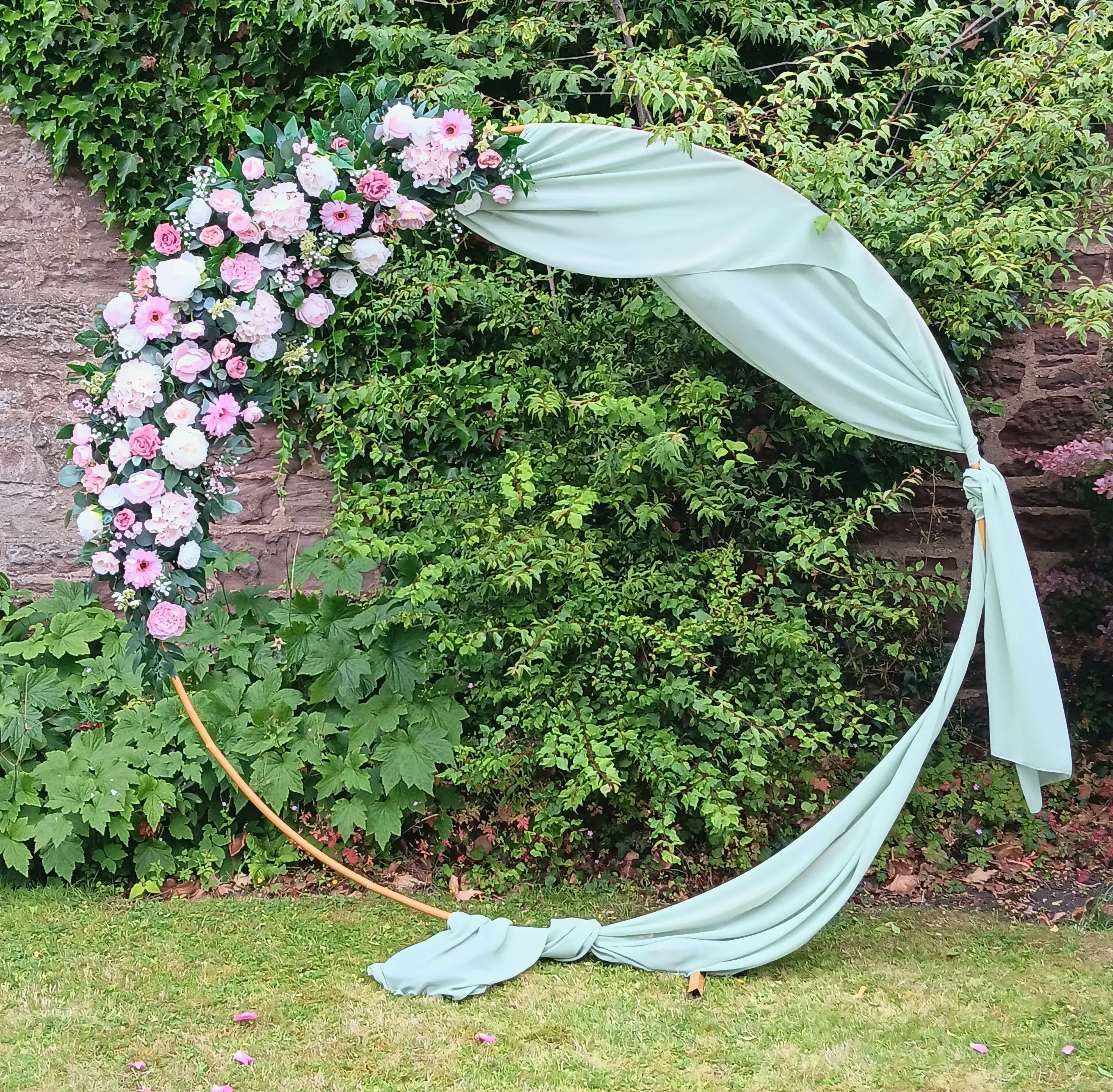 outdoor ceremony circle arch in sage green and pinks 