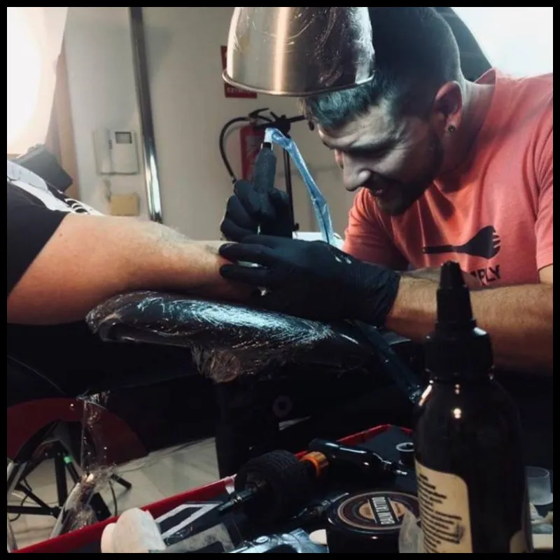 Imagen de Arantxa tatuando, propietaria del estudio de tatuaje