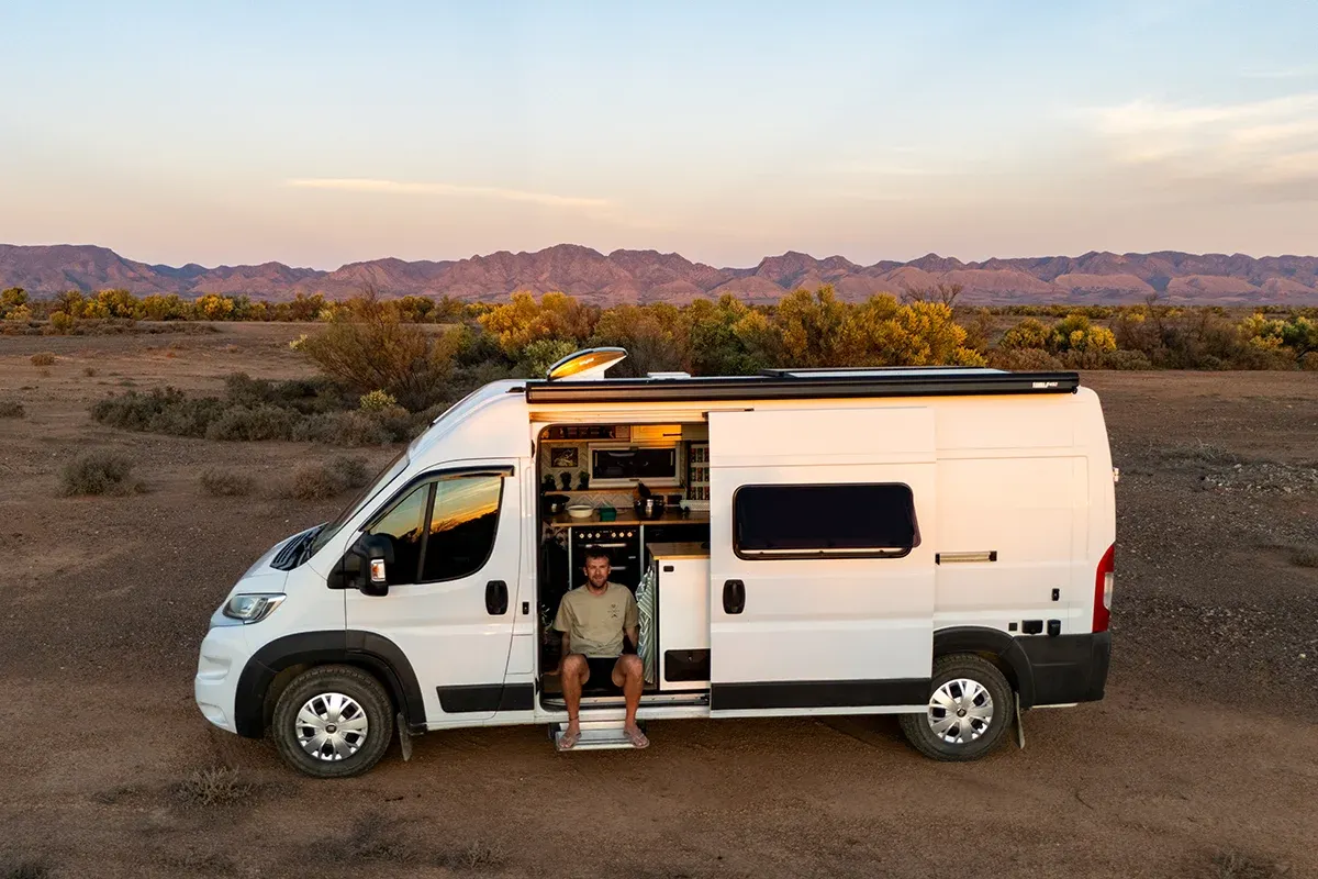 Self-built campervan parked in the Australian outback during sunset