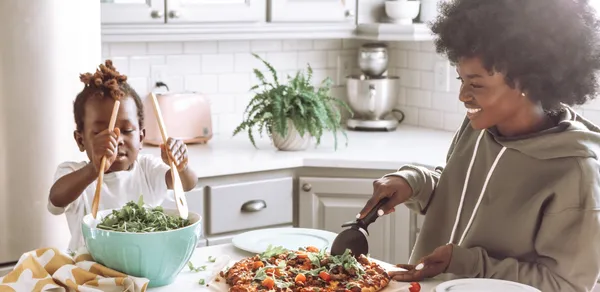 parent and child preparing food in kitchen