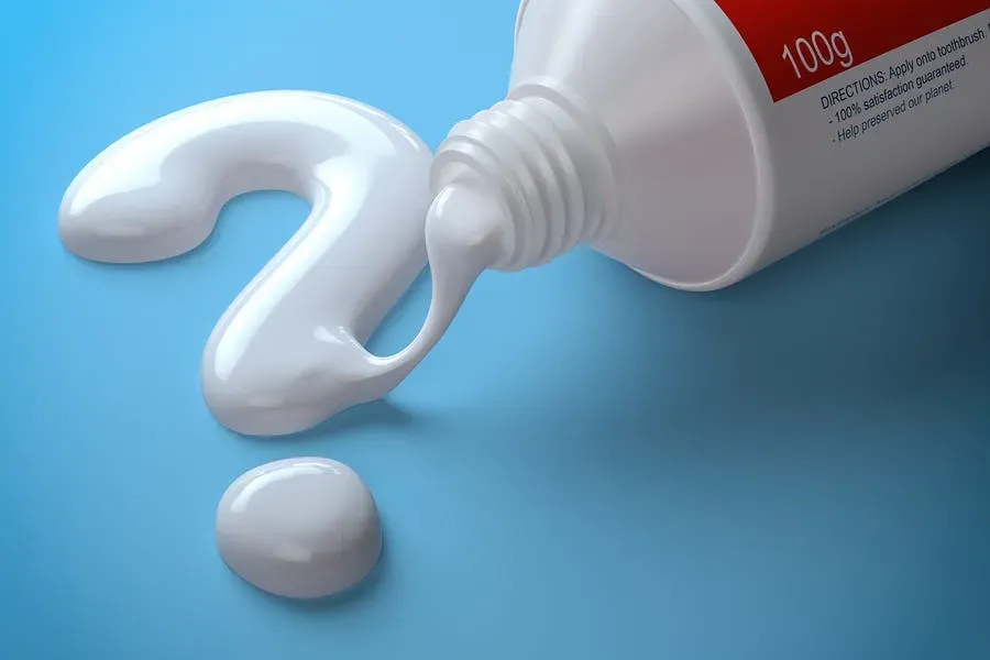 Toothpaste tube with toothpaste coming out in the form of a question mark