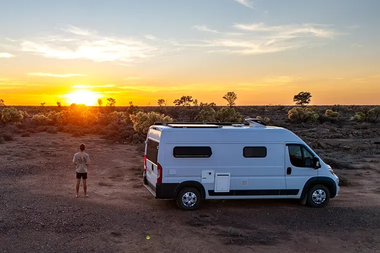 Self-built campervan parked in the Australian outback during sunset