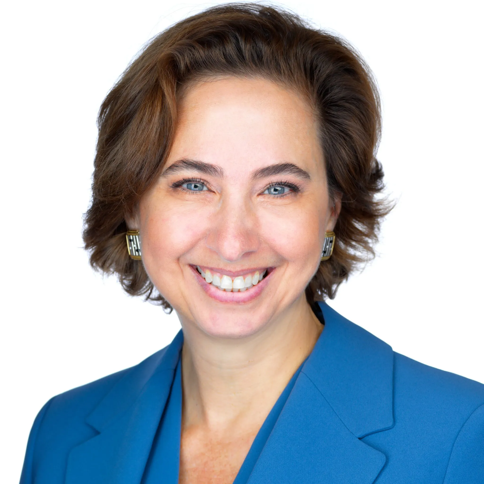 Professional portrait of a woman in a bright blue blazer smiling posed in front of a white backdrop