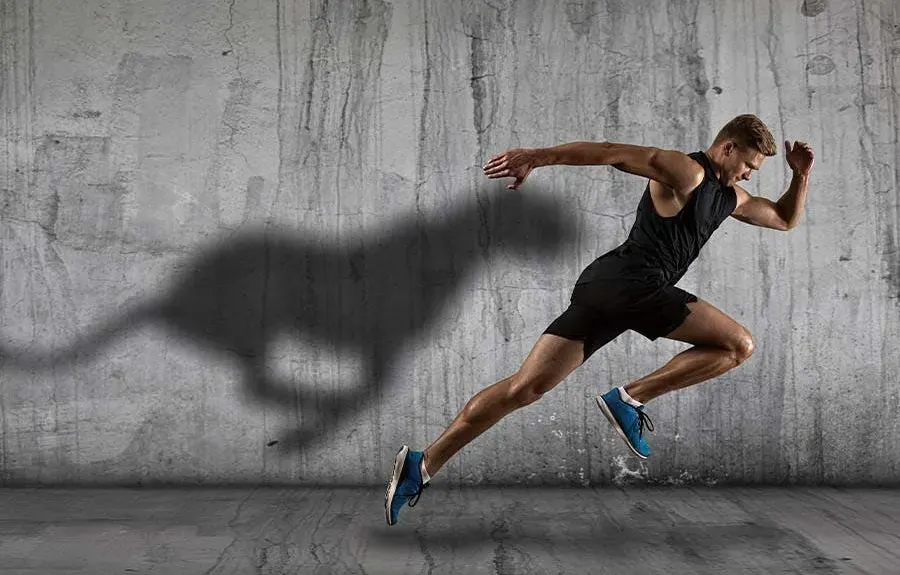 man running next to wall. his shadow looks like a chetah.