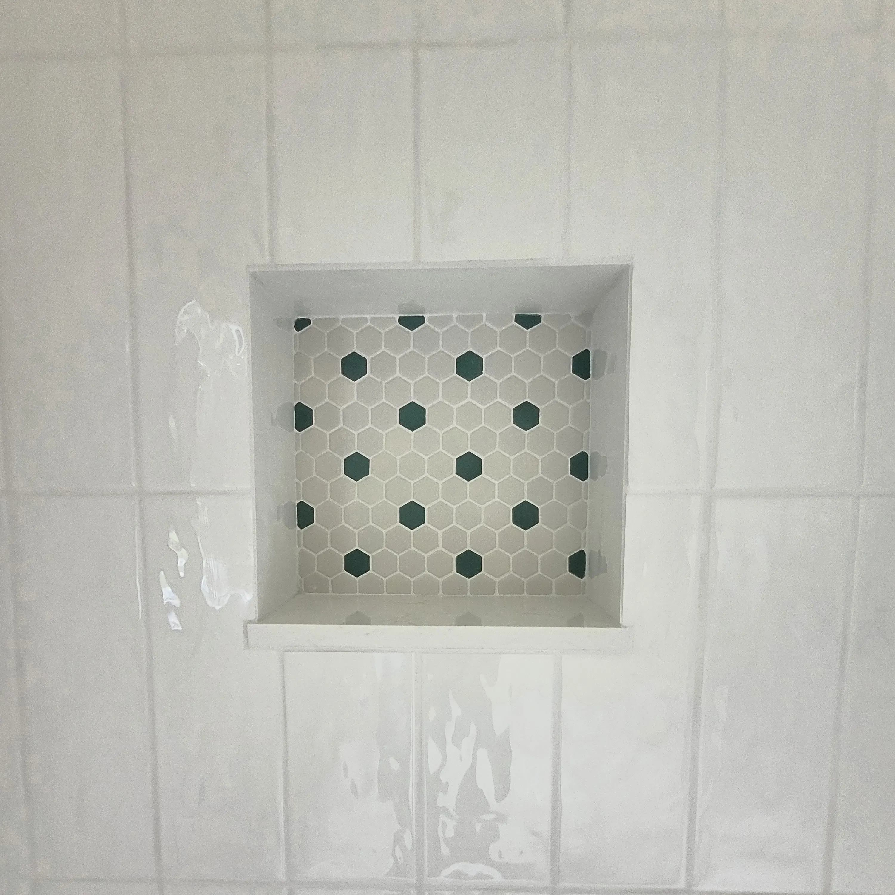 white tile shower wall with nook 
