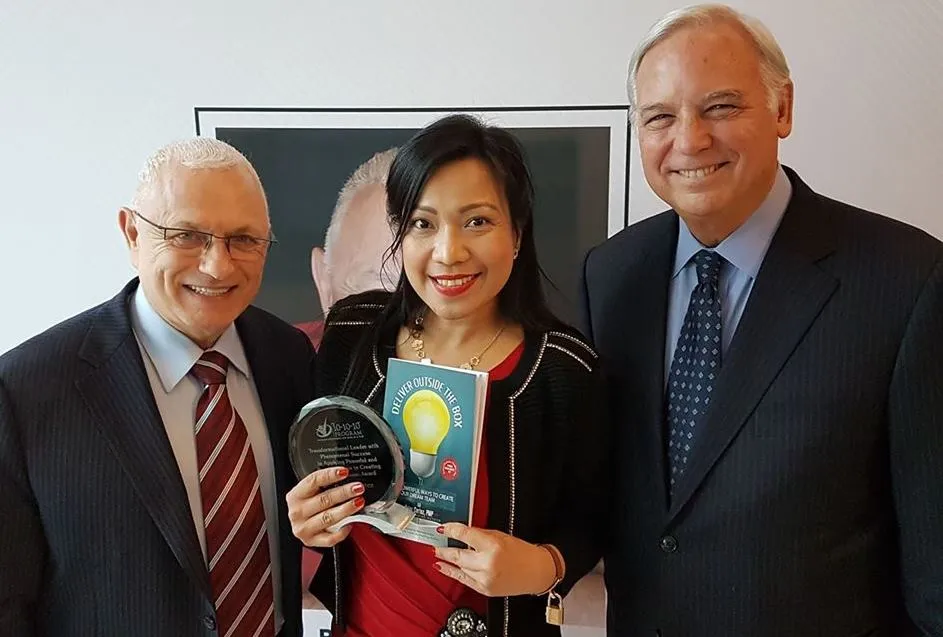 Dr. Ma Cherie Cortez receiving the award for Transformational Leadership award in Toronto, Canada in 2018 with Raymon Aaron and Jack Canfield, Author of the Chicken Soup for the soul.