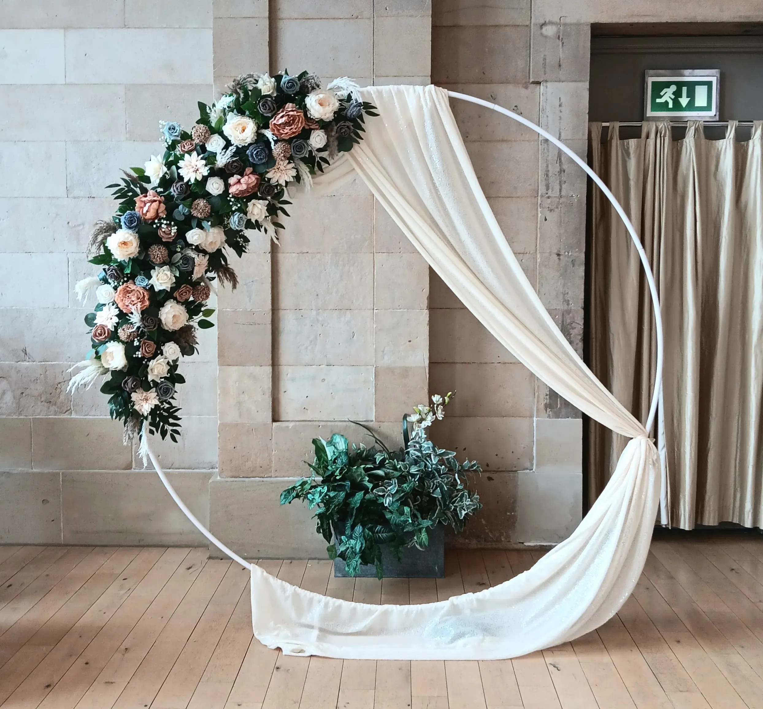 champagne and shades of brown florals with whisps of pampas and a champagne sequin drape