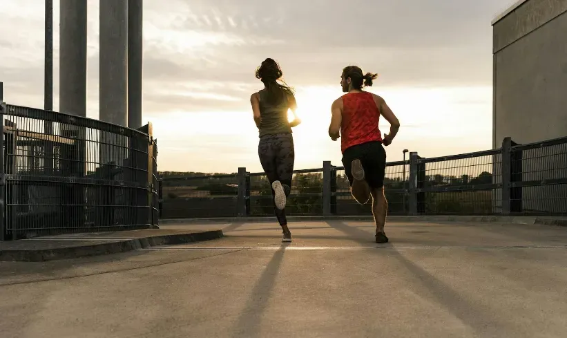 Two people jogging into the sunset.