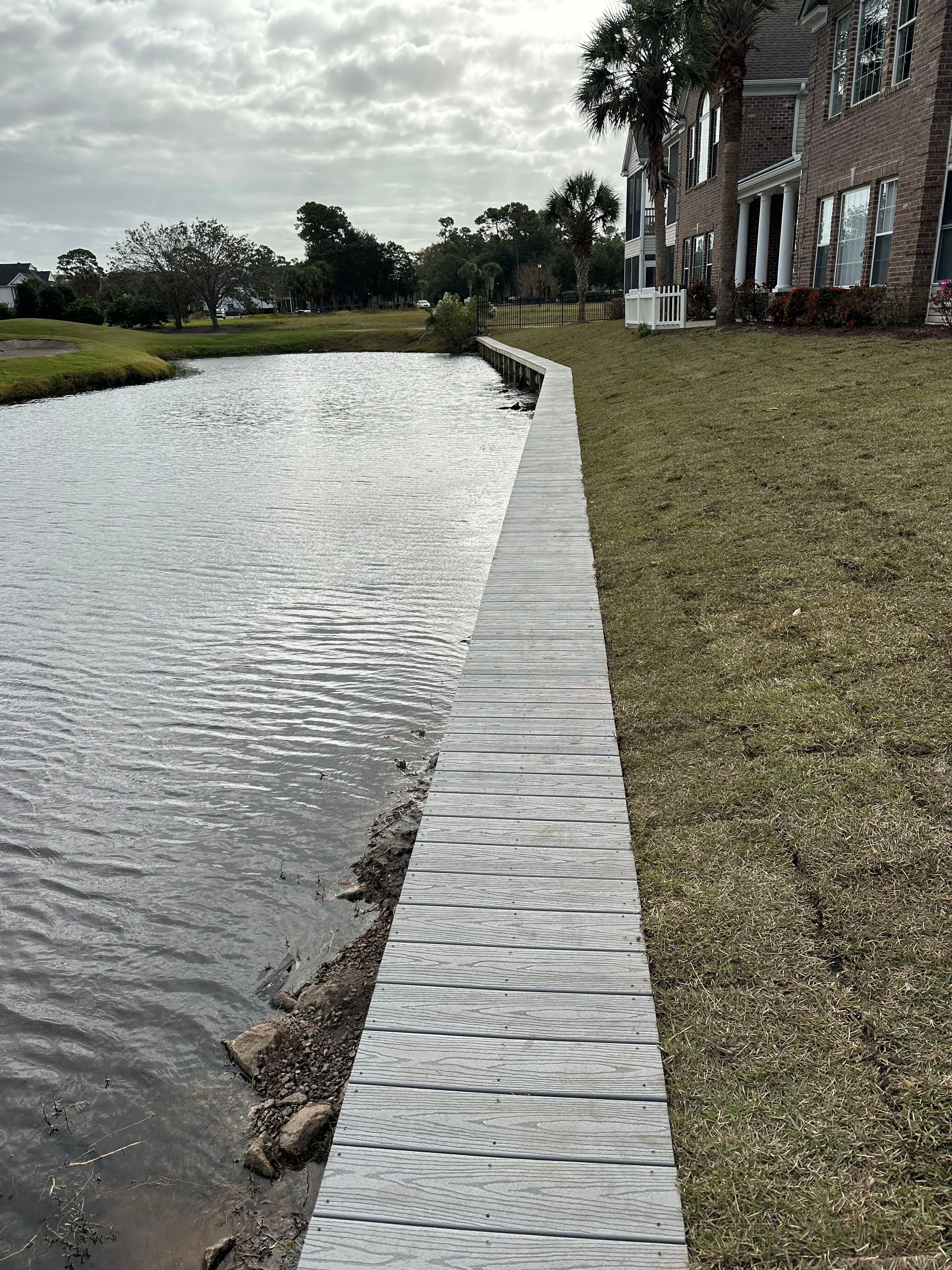 Vinyl Bulkhead with composite wood cap in Murrells Inlet SC on a golf course lake built by Waterbridge Contractors of the Carolinas