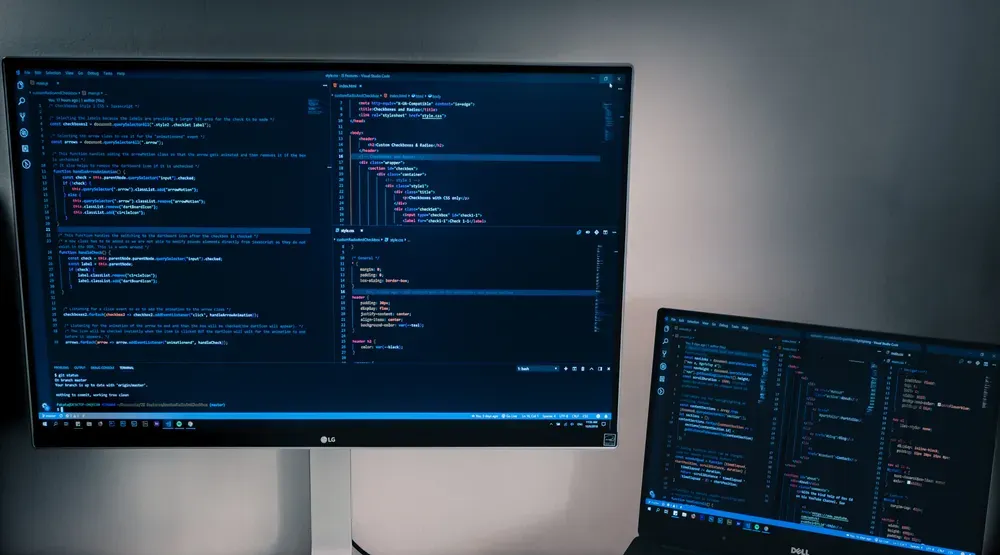 Two computer screens displaying html coding
