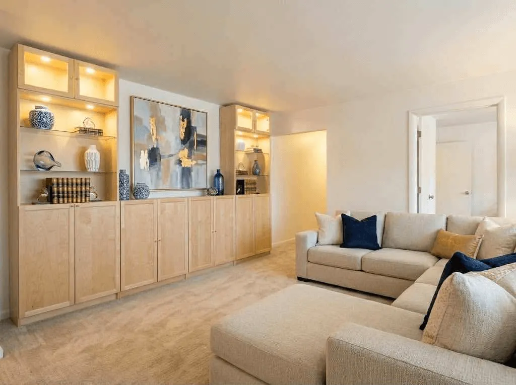 <alt=“Contemporary living room inside AHA Global Holdings furnished corporate apartment in Ann Arbor, with modern sectional sofa, premium decor, and soft ambient lighting.”>