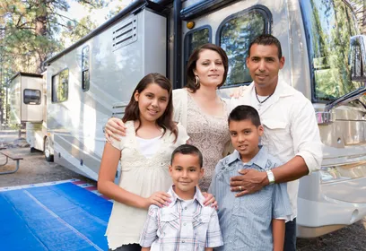 family of four infront of an RV