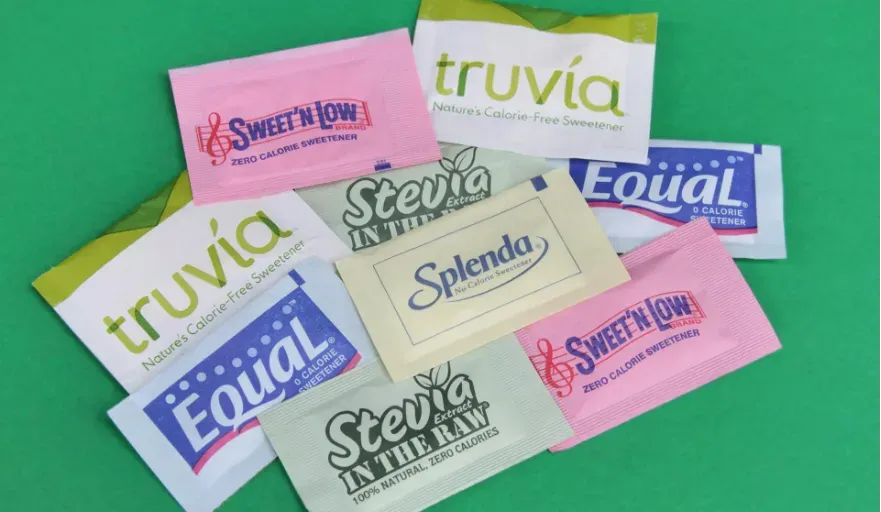 A bunch of little packets of the main artificial sweeteners and sugar substitutes.