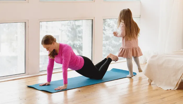 A mom trying to workout while her kids are running around.
