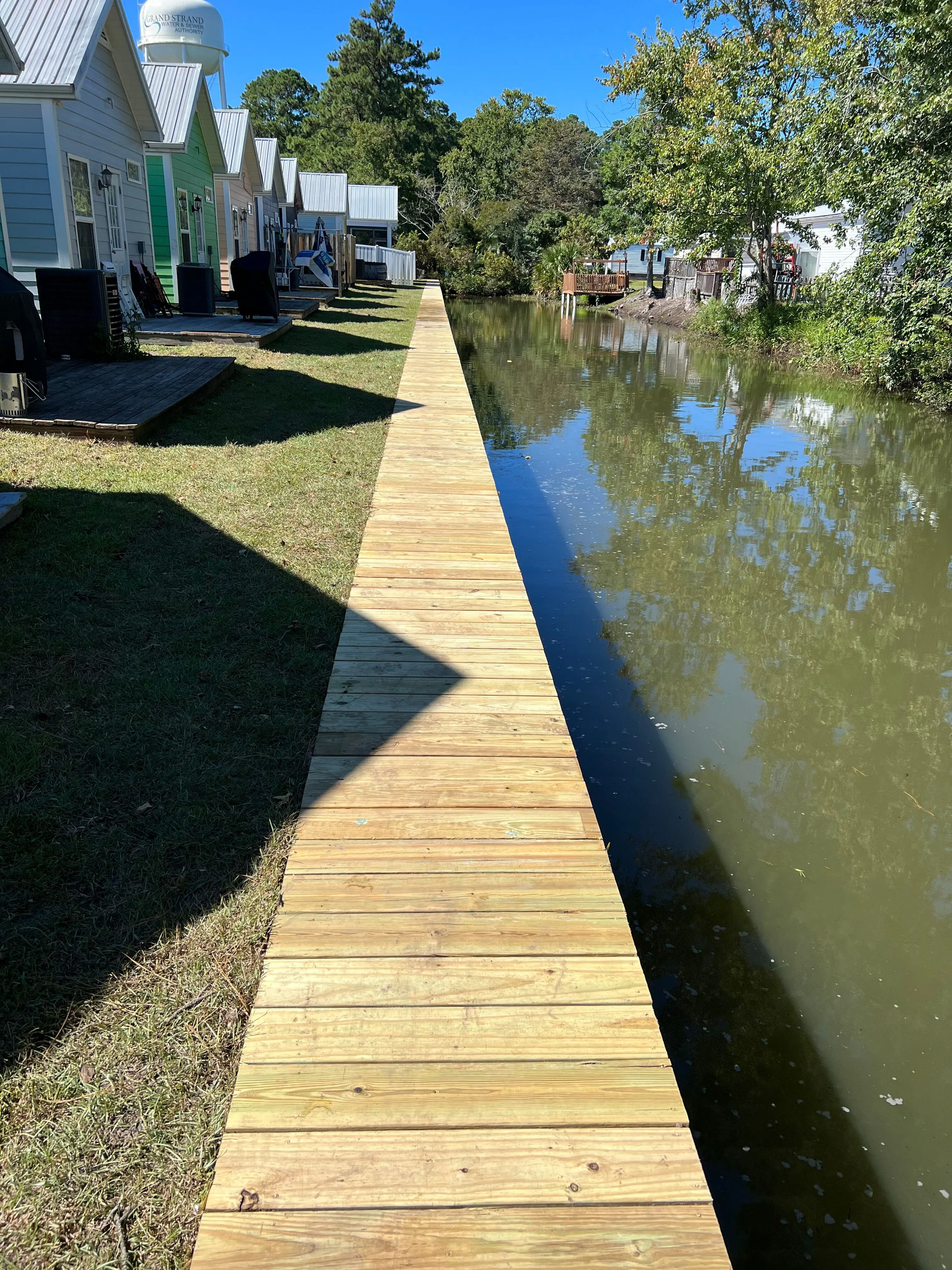 Vinyl Bulkhead with wood cap in Garden City Beach SC on a retention pond built by Waterbridge Contractors of the Carolinas
