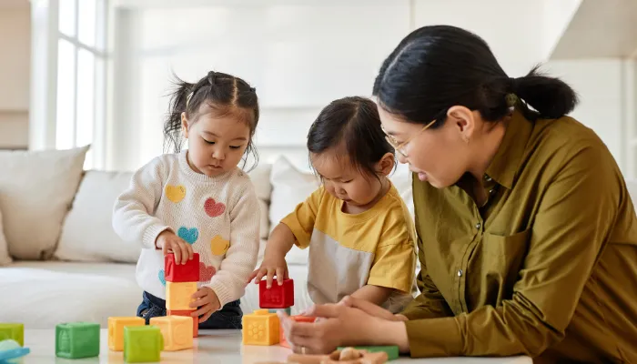 Mom playing blocks with her kids.