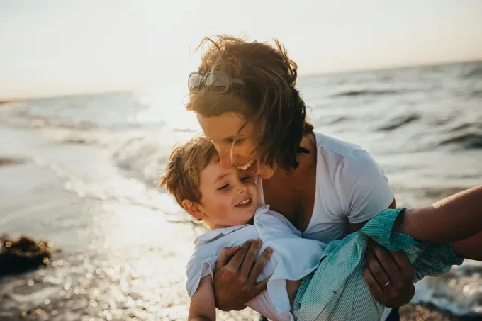 mom playing with her son in the beach