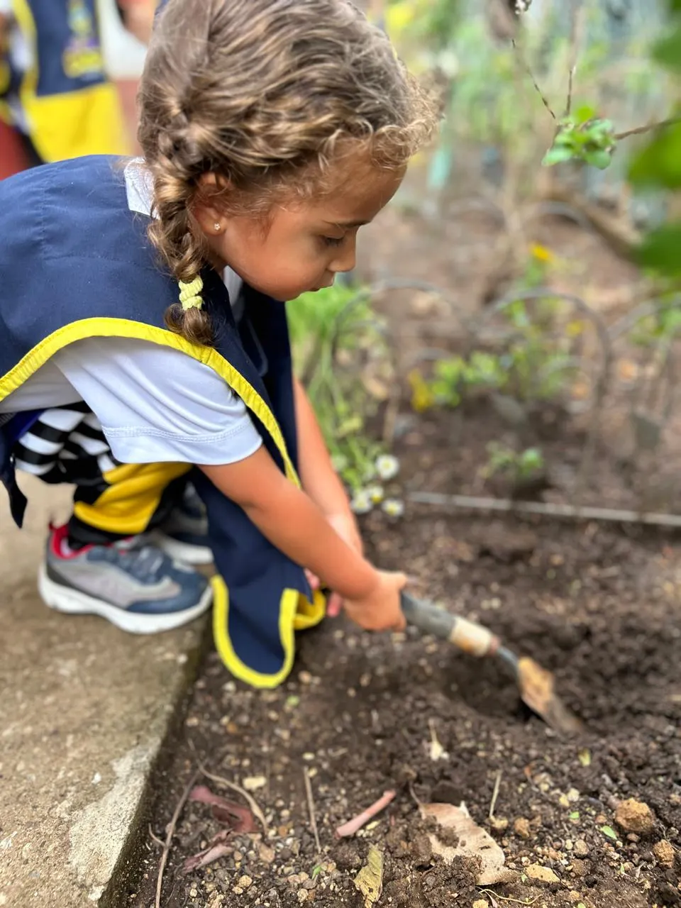 Niña aprendiendo a sembrar en Colegio WonderBees, Cayalá zona 16