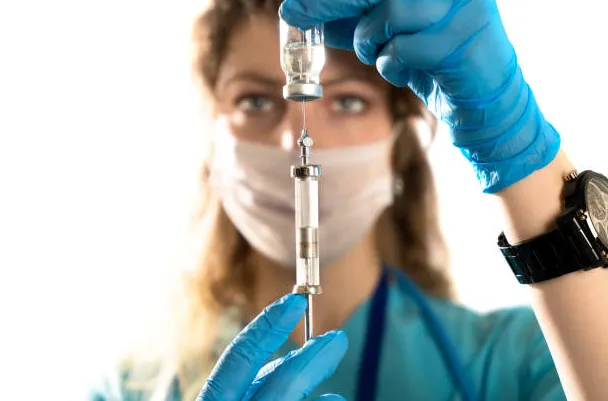 a female anesthesiologist preparing a needle for injection