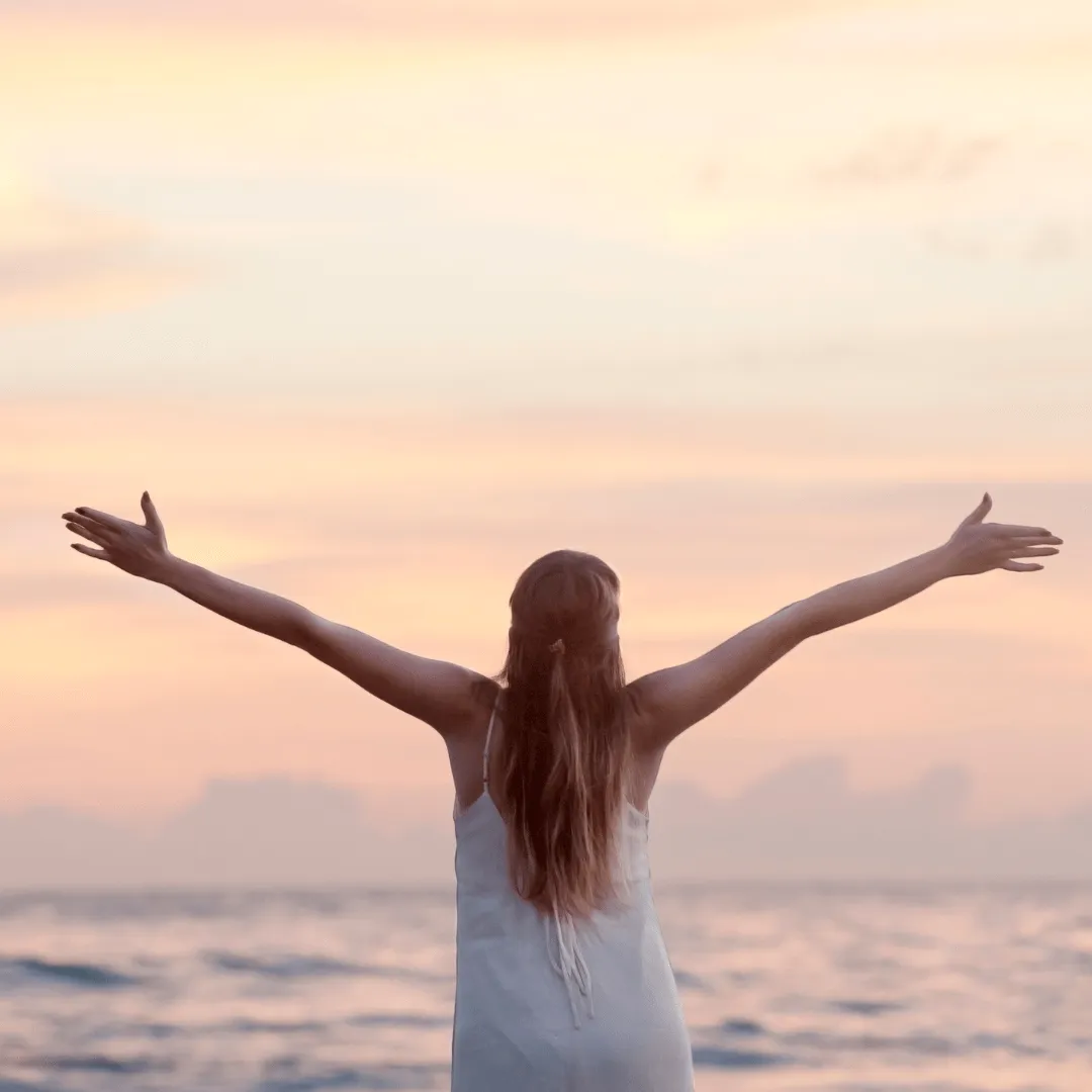 woman-open-wide-arms-in-front-of-the-ocean