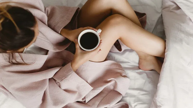 Woman in robe cuddling a cup of coffee. too busy for anything else