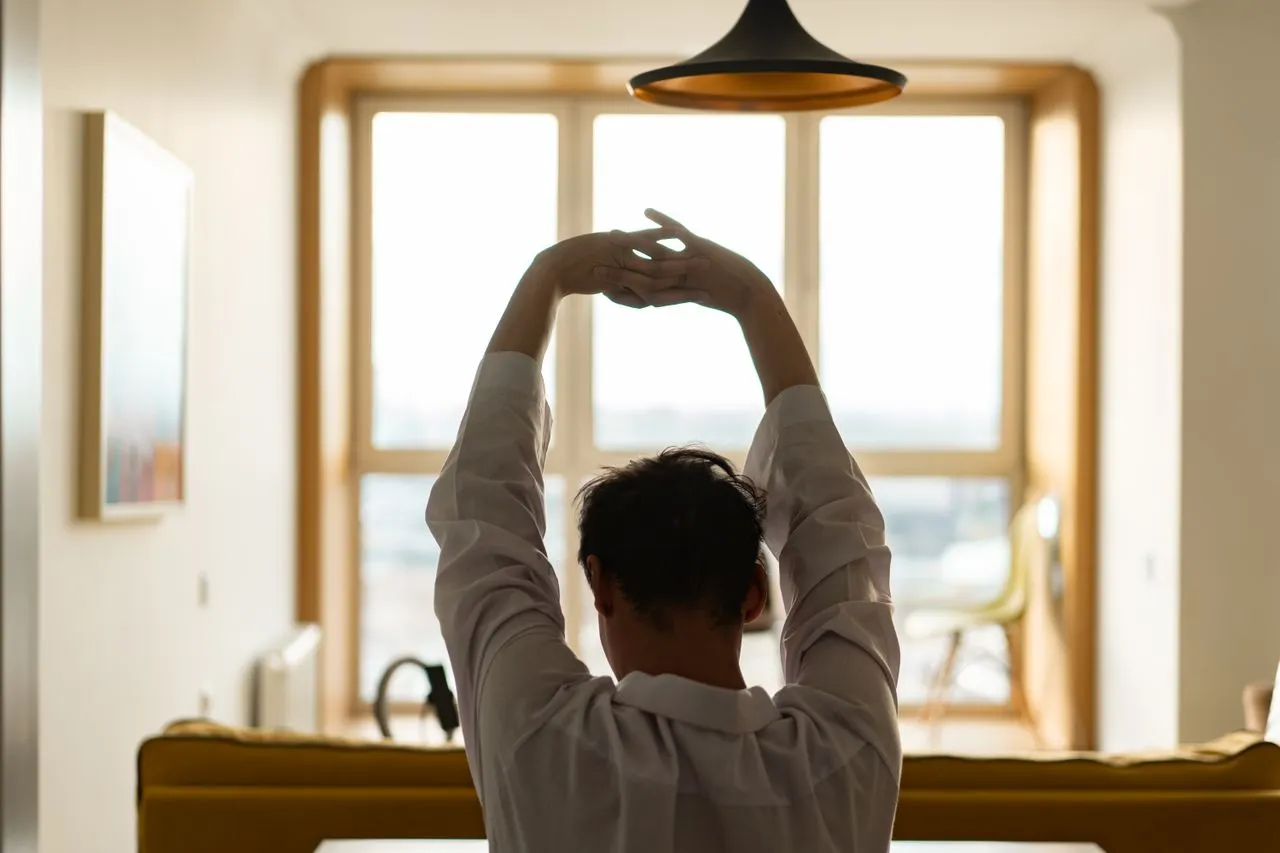 Woman stretching in morning sunlight for energy