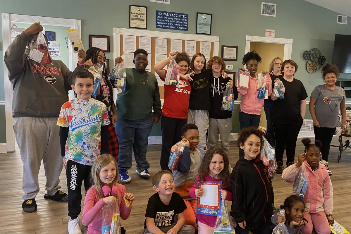 Distributing hygiene toiletries to children at Mt. Vernon Apartments community event