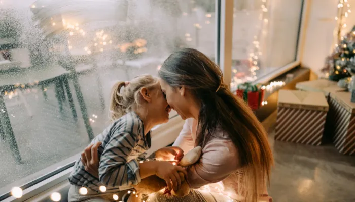 A mom and daughter laughing and hugging.