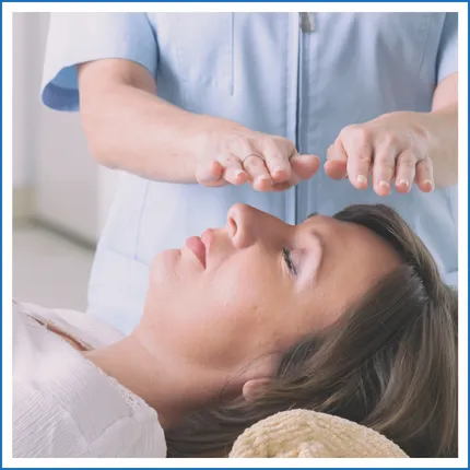 Woman doing reiki on a patient