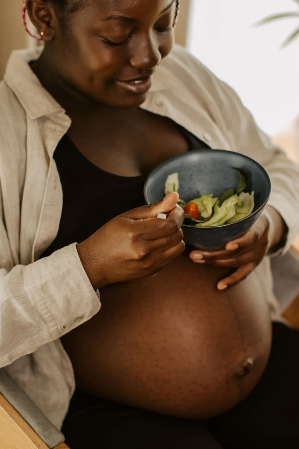 pregnant african american woman eating a healthy meal