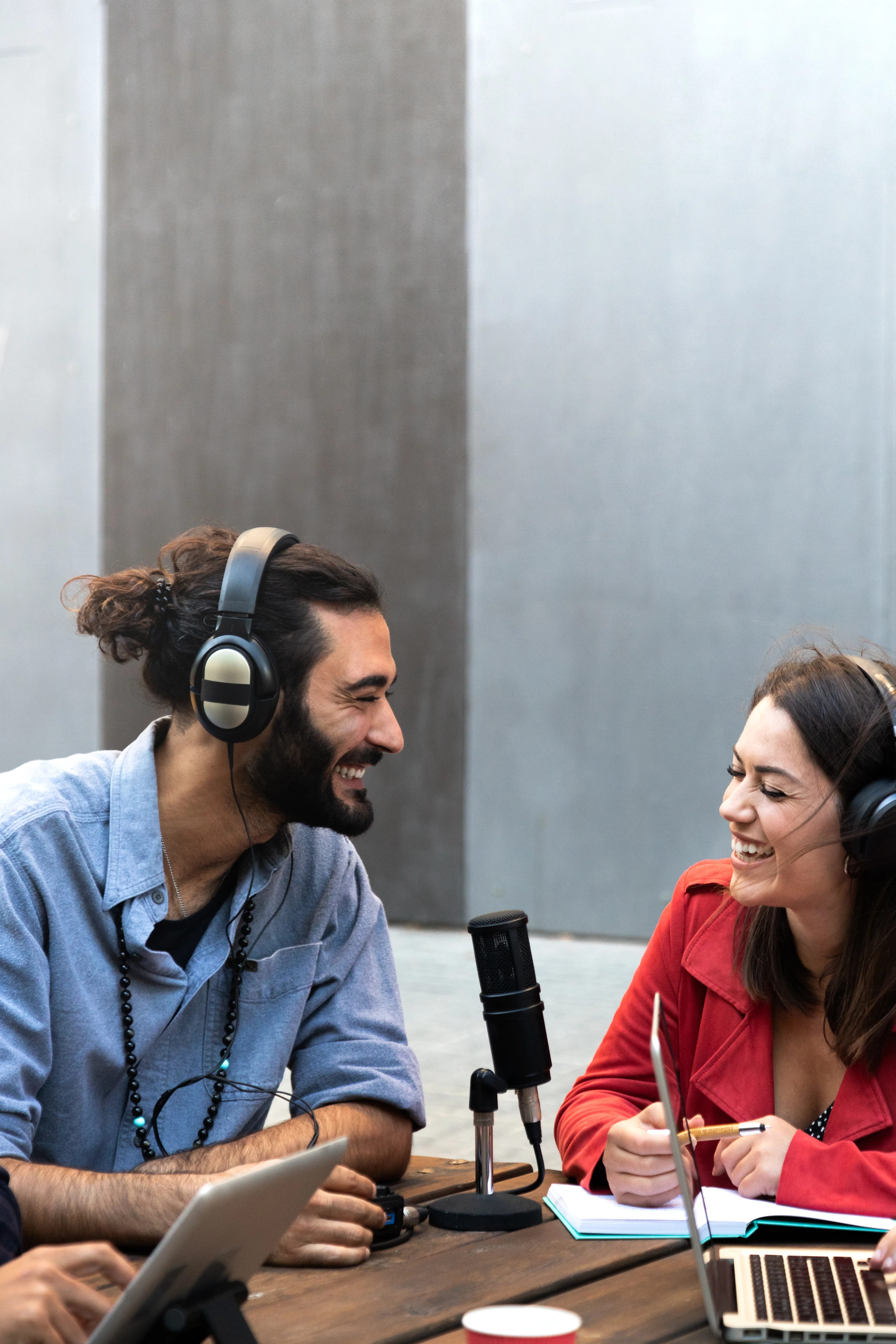 A man and a woman sitting at a mic doing a podcast