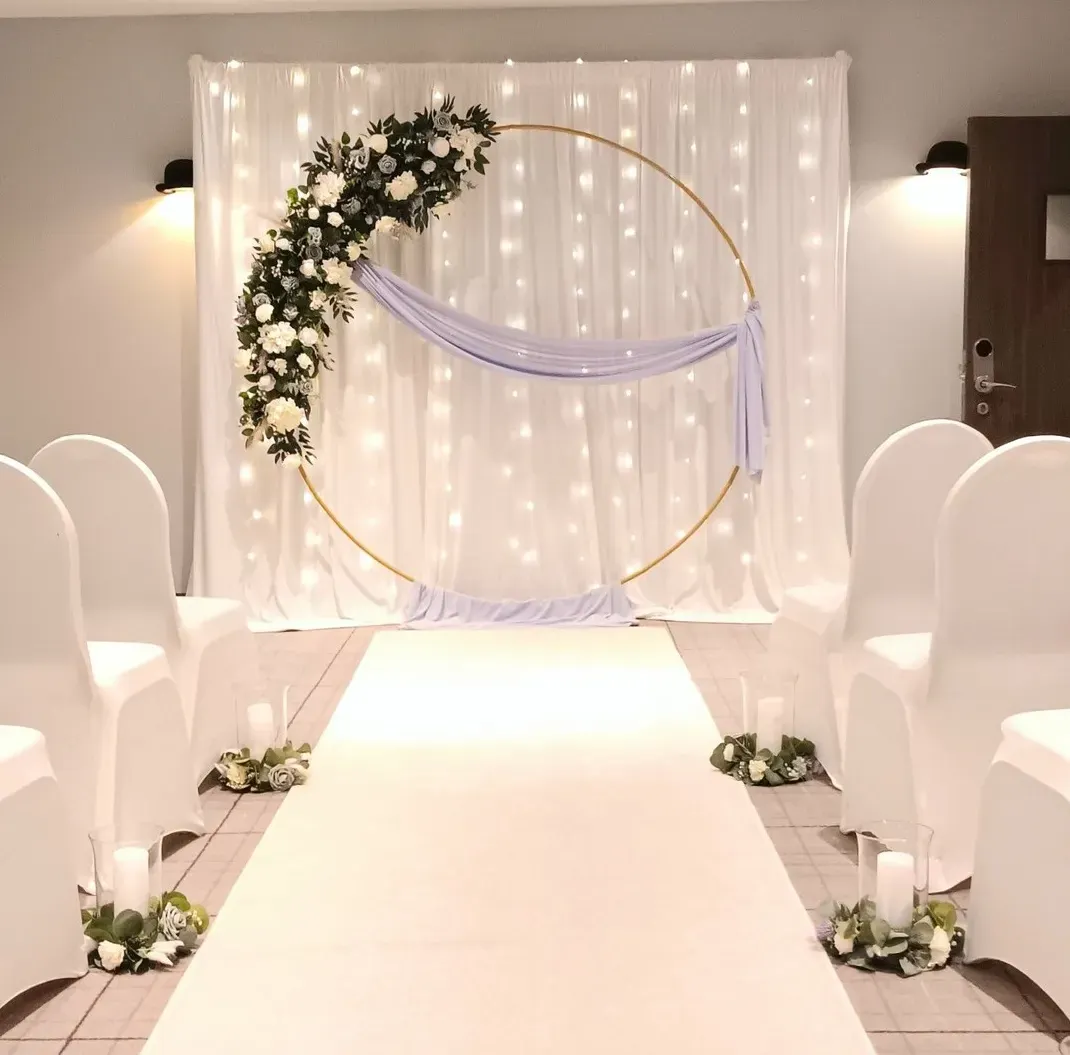 white LED backdrop with bespoke lilac and thistle circle arch and aisle decor
