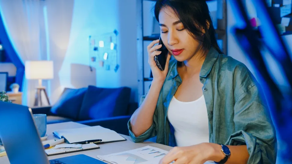 Asian woman on phone at desk