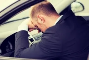 Man sitting in a car frustrated