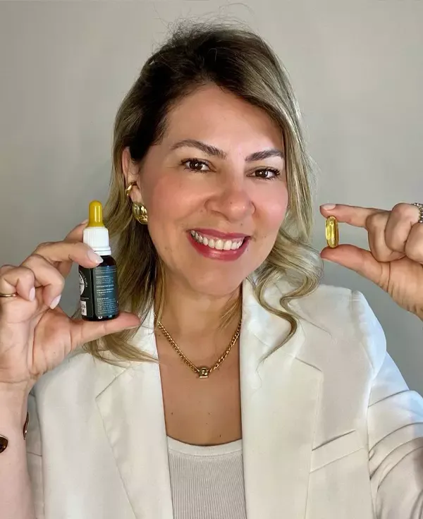 Doutora Érica Moura segurando uma pílula e um remédio
