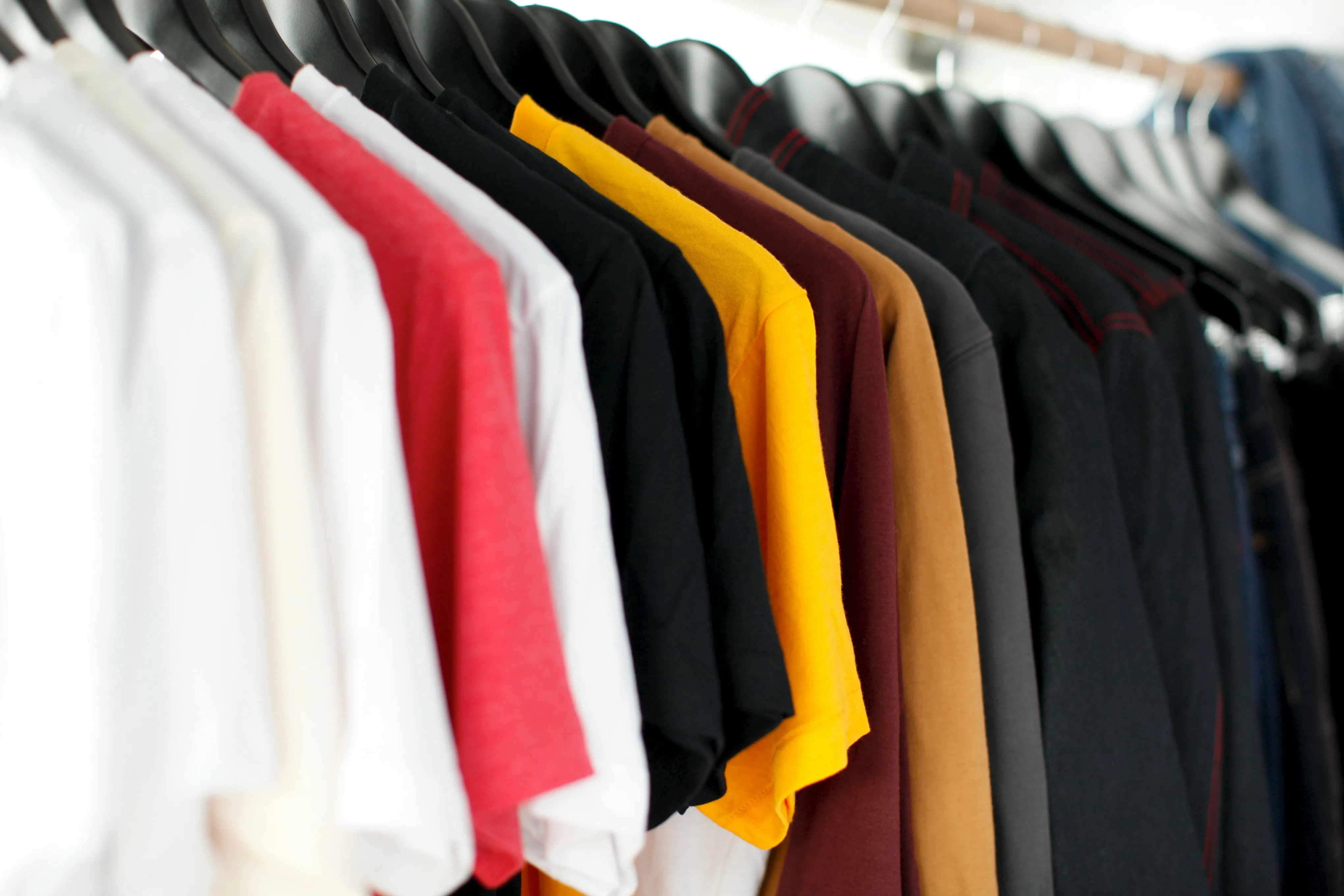 Assorted T-shirts displayed to represent research and comparison of manufacturer offerings in custom apparel production. Create your own shirts now!
