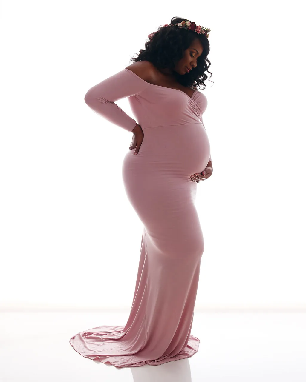 maternity photos studio | pregnant woman of color silhouetted on white background cradling her belly | maternity studio photo shoot | Washington DC