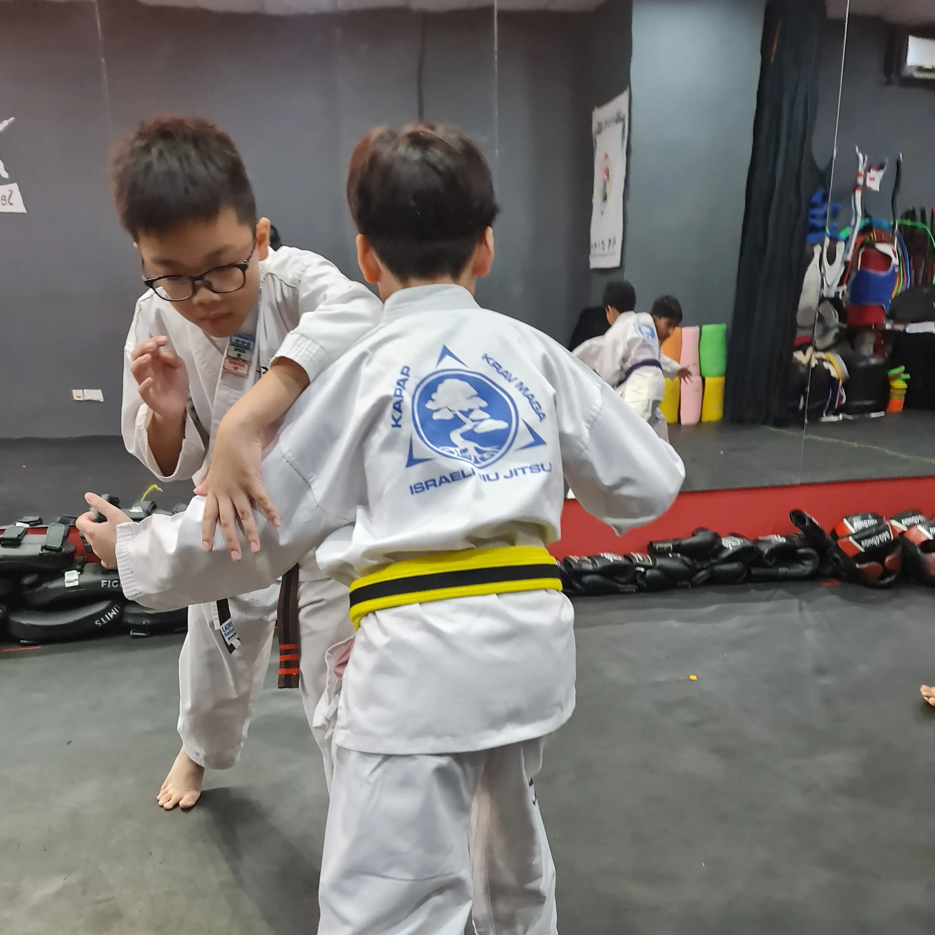 Children practising Integrated Jiujitsu through active partner interaction at CADRE Academy.